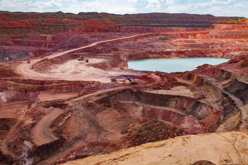 Photo of a vast aluminium mine, with red-coloured rocks