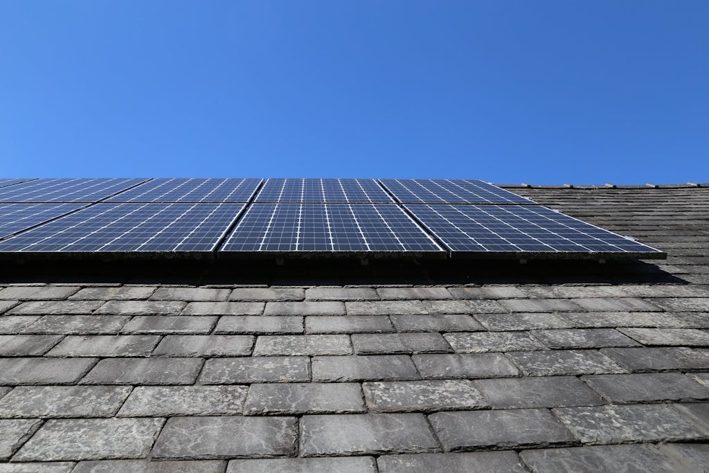 Solar panels on a slate roof, under a blue sky