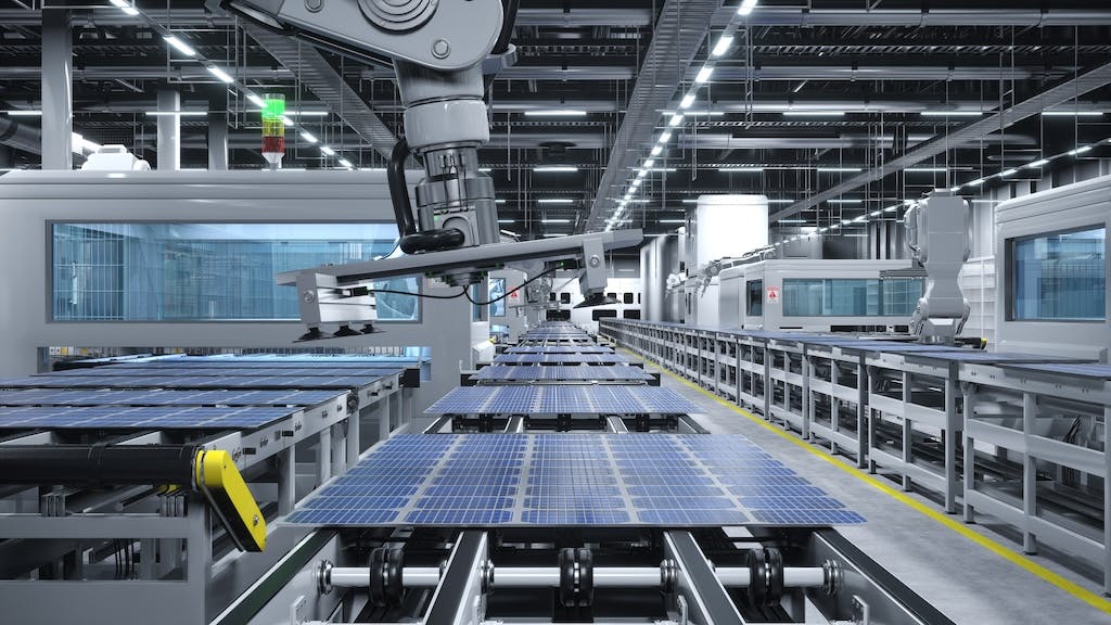 Solar panels moving along a production line in a factory, robot arms above them