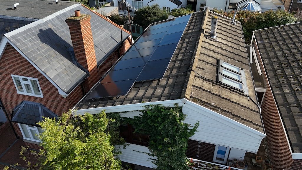 Black solar panel array on a rooftop viewed from above