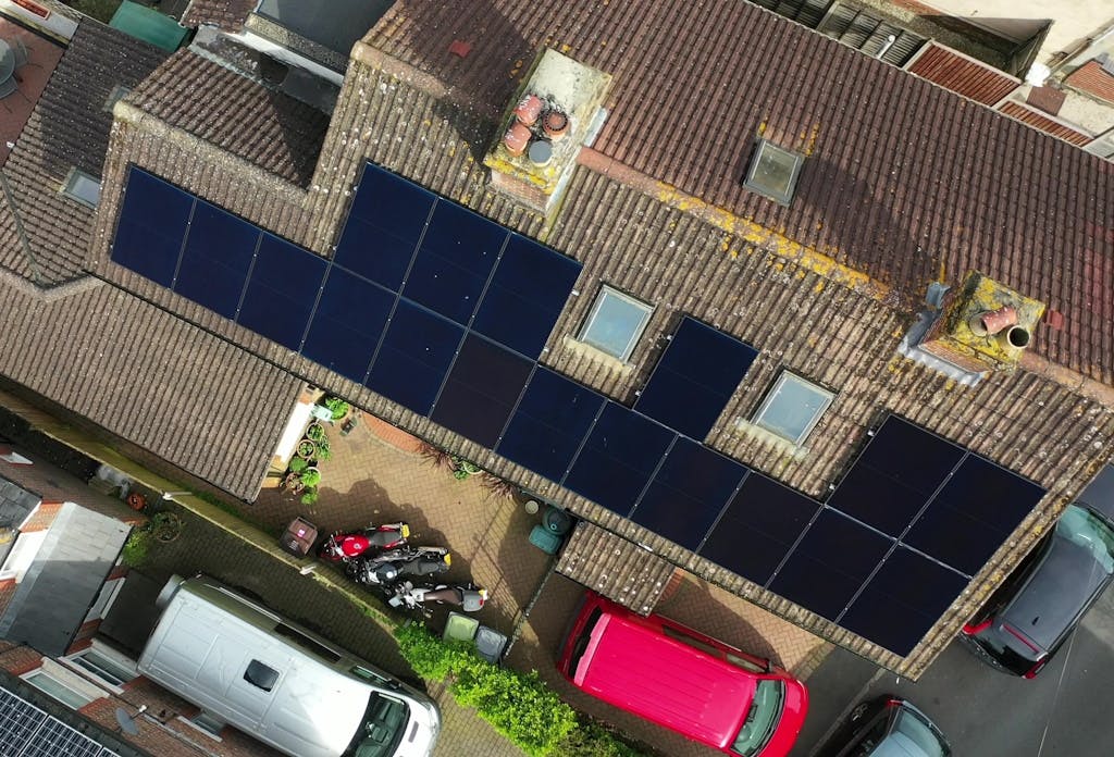 bird's-eye view of black solar panels on a brown roof