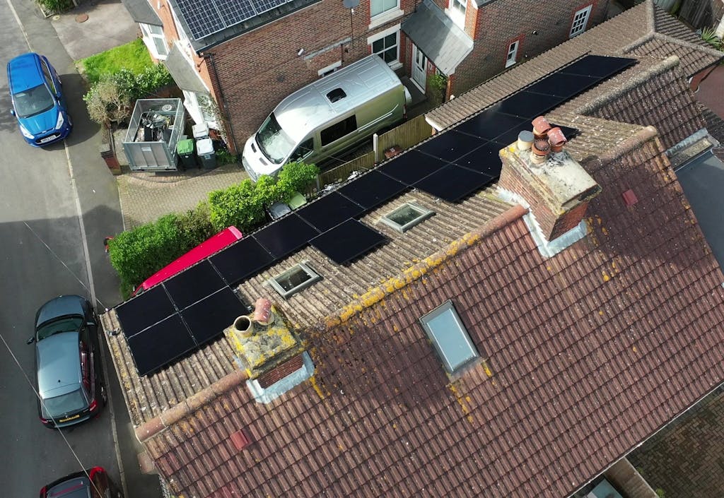 bird's-eye view of black solar panels on a brown roof