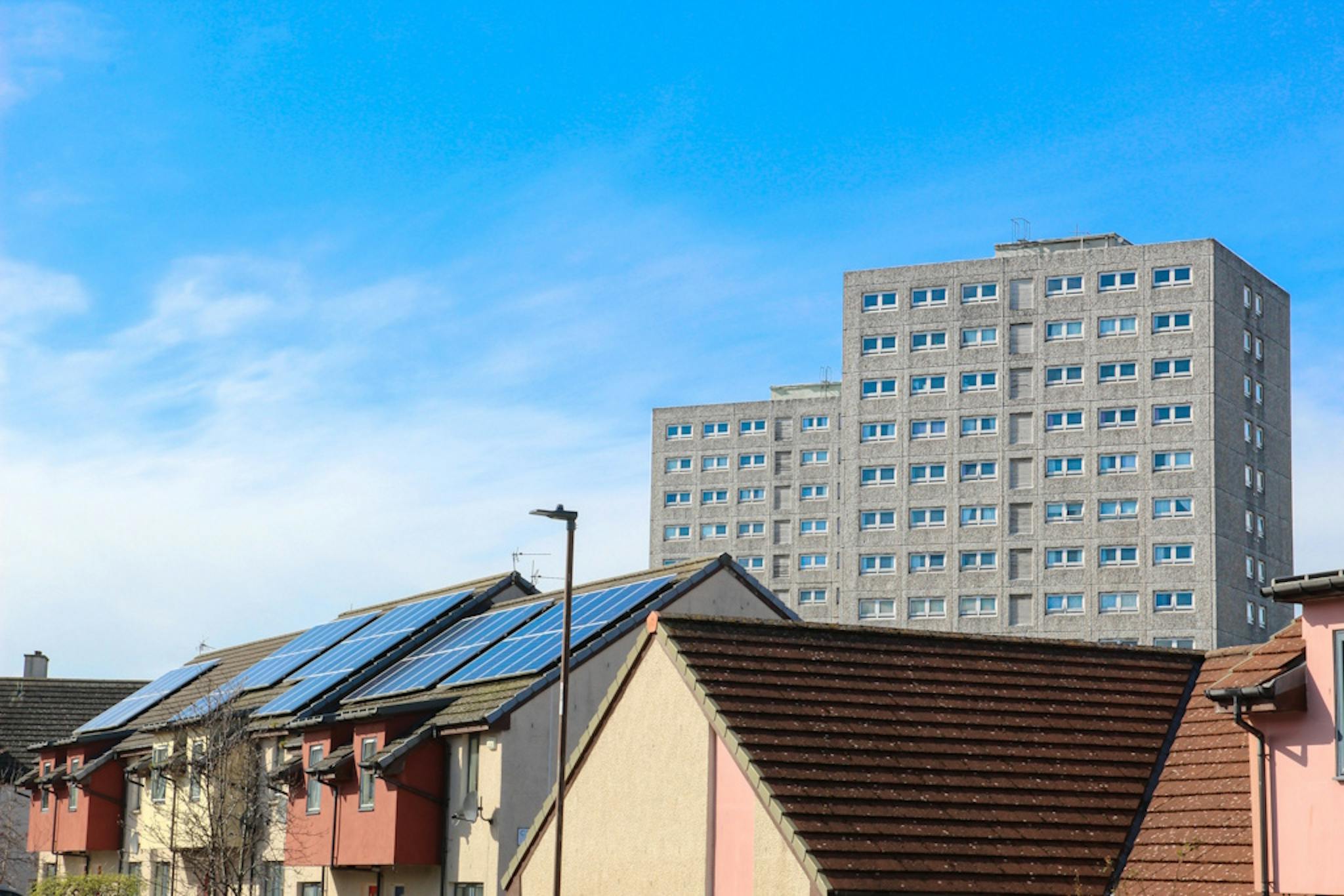 houses with solar panels, under a blue sky