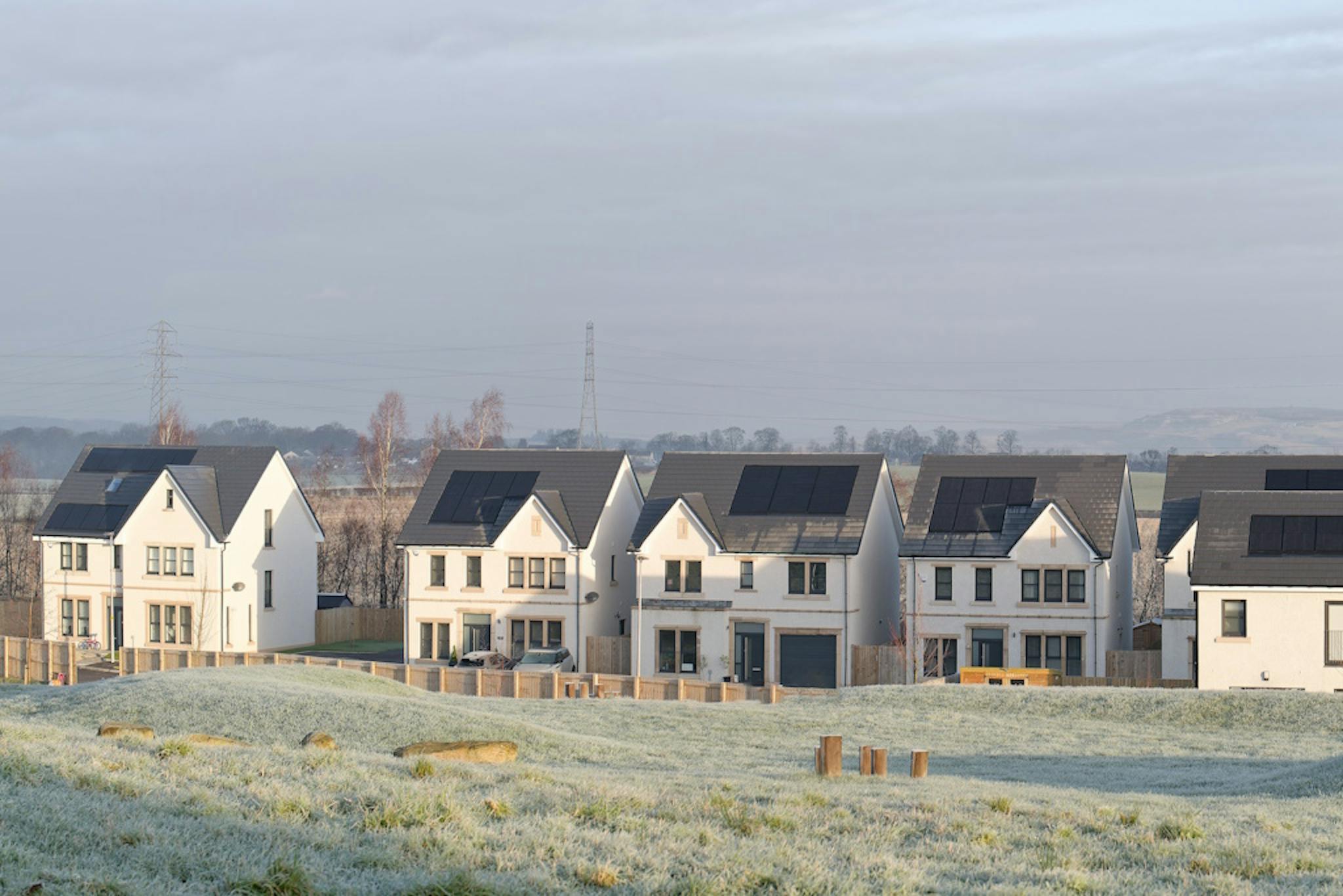 homes with solar panels, by a grassy area