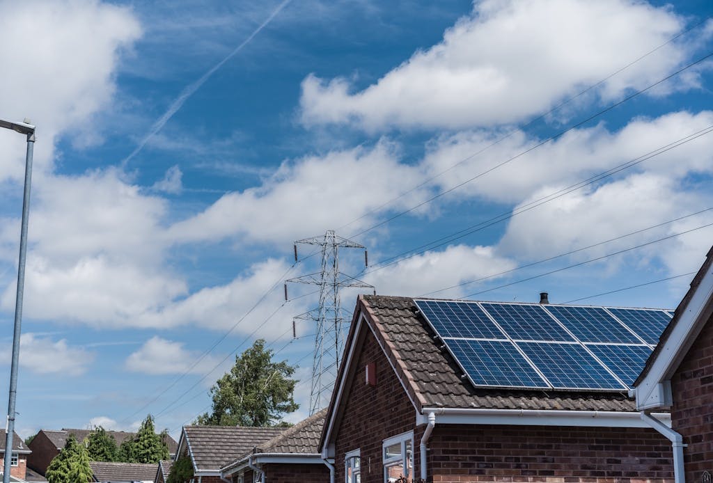solar panels on a brown roof, under a blue sky with clouds