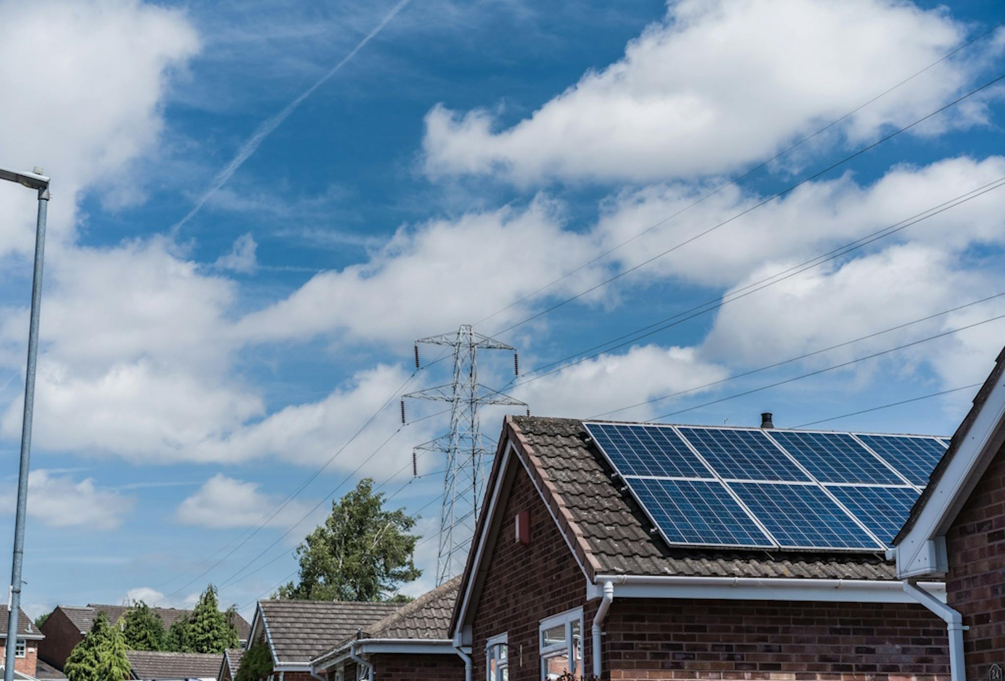 solar panels on a brown roof, under a blue sky with clouds