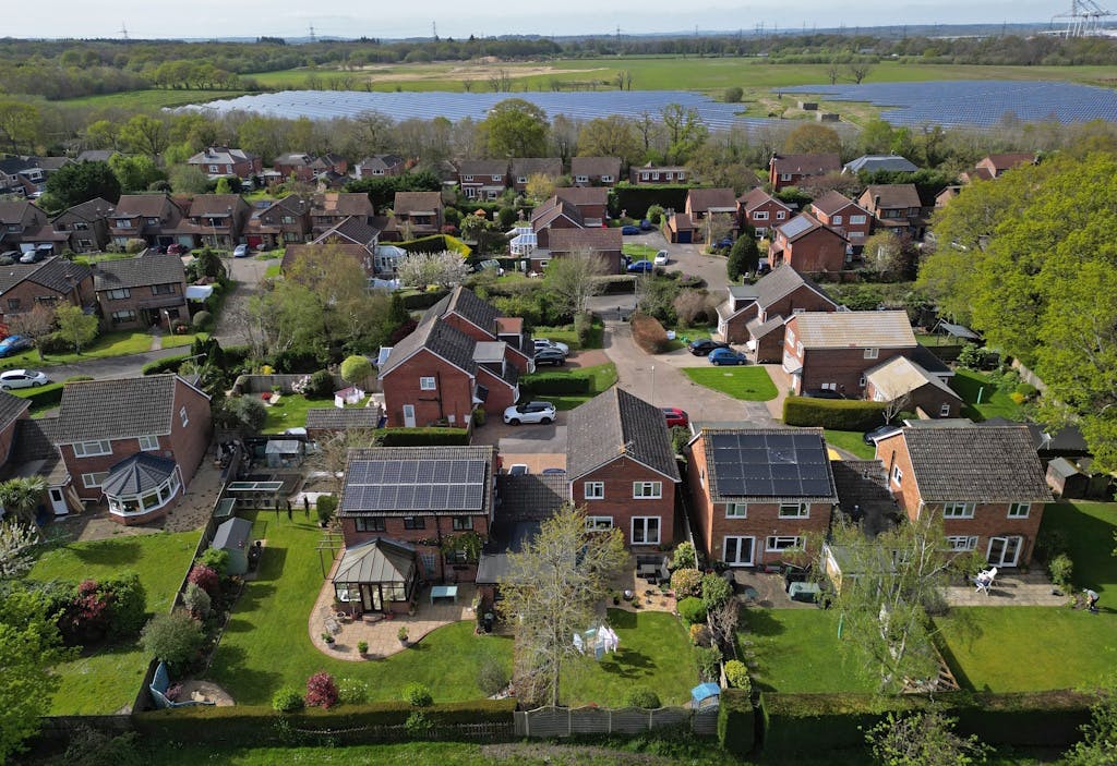 solar panels on the roofs of houses in a green area