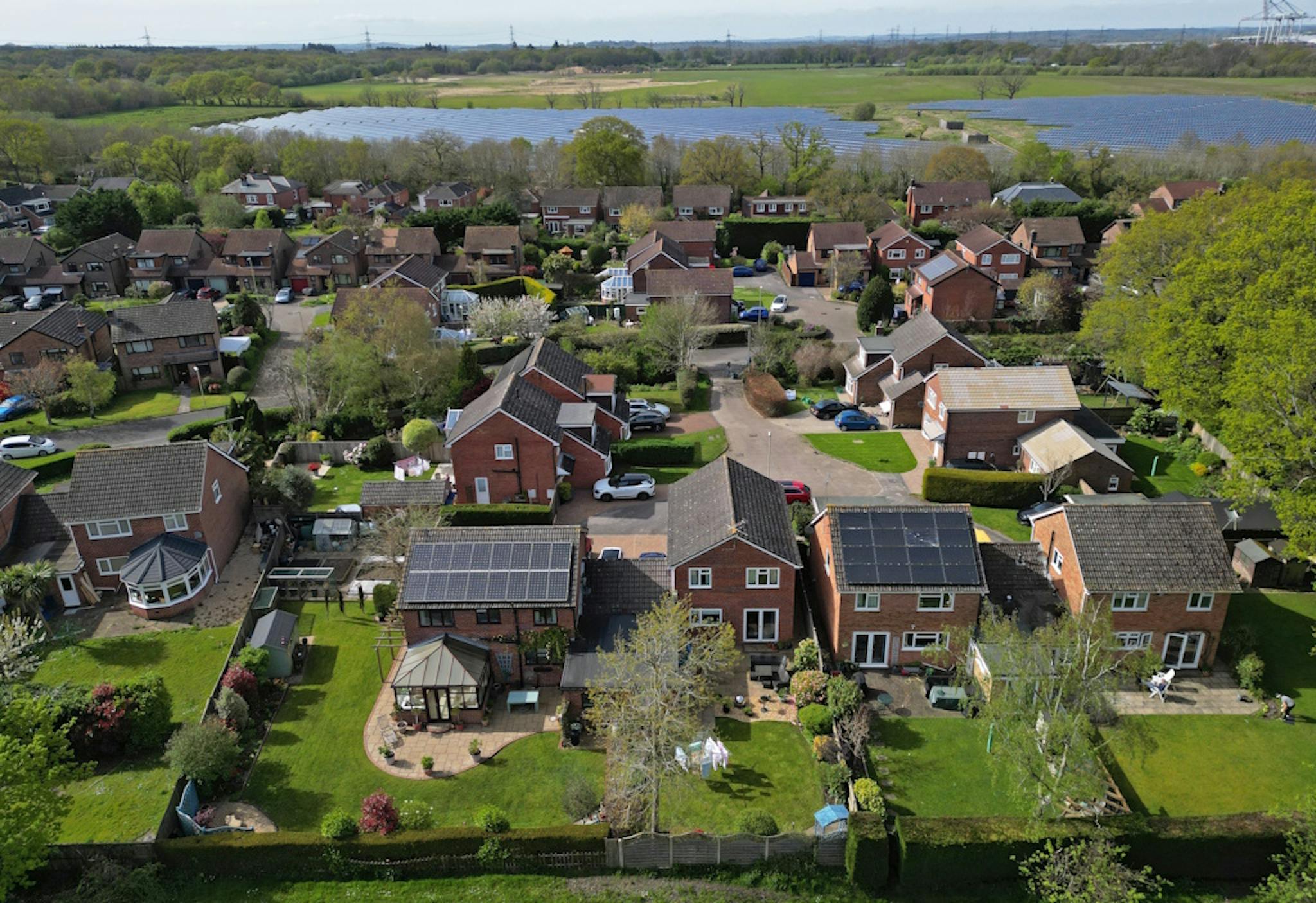 solar panels on the roofs of houses in a green area