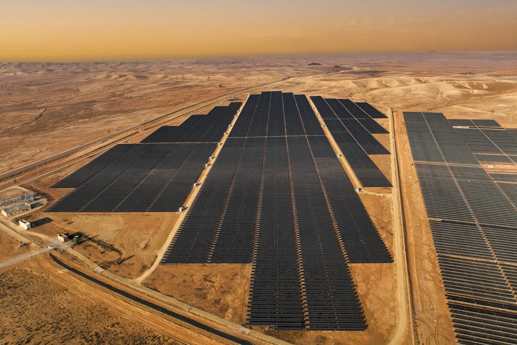 bird's eye view of black solar panels in a desert