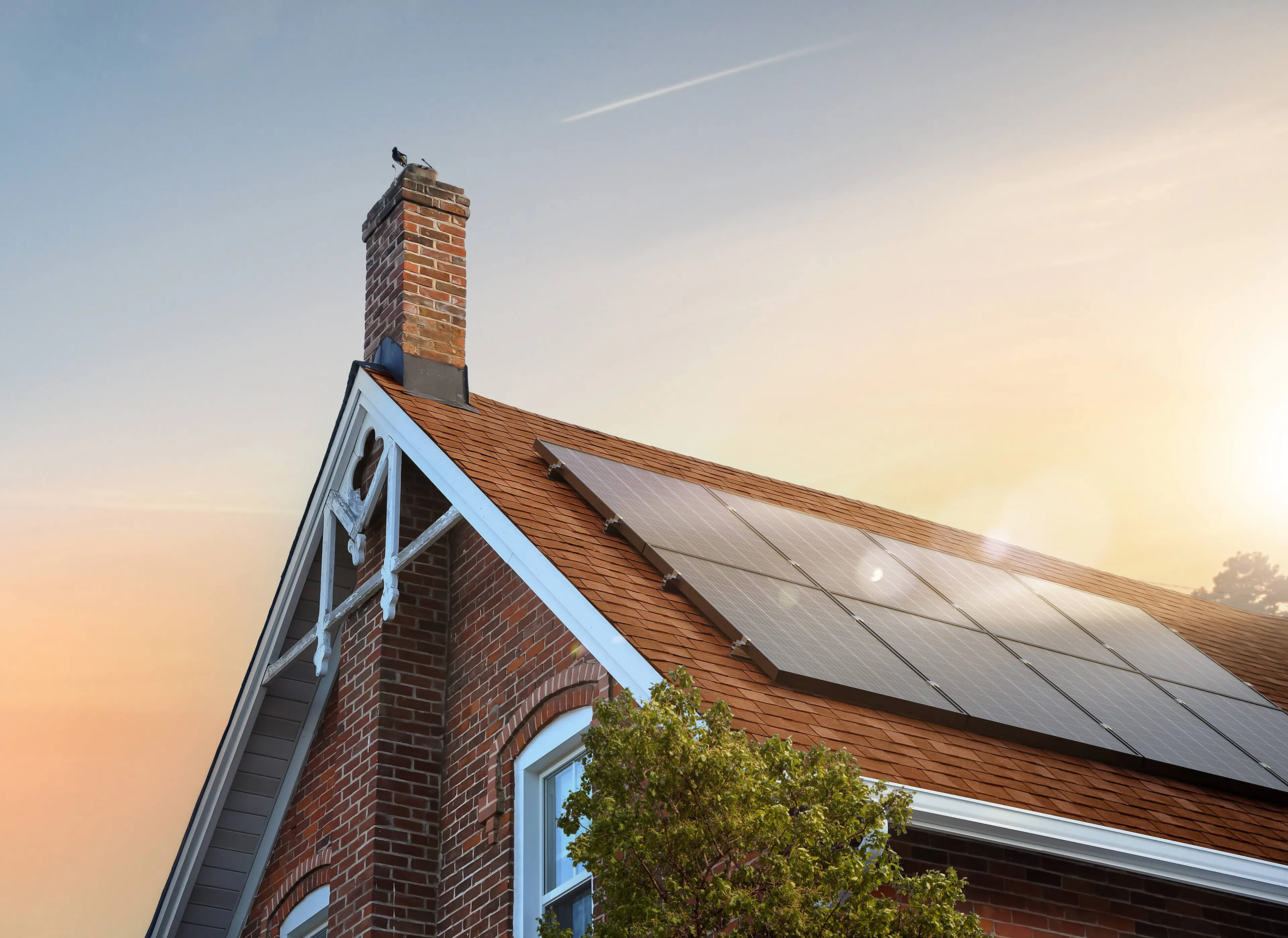 Solar panels on roof, with sunset behind