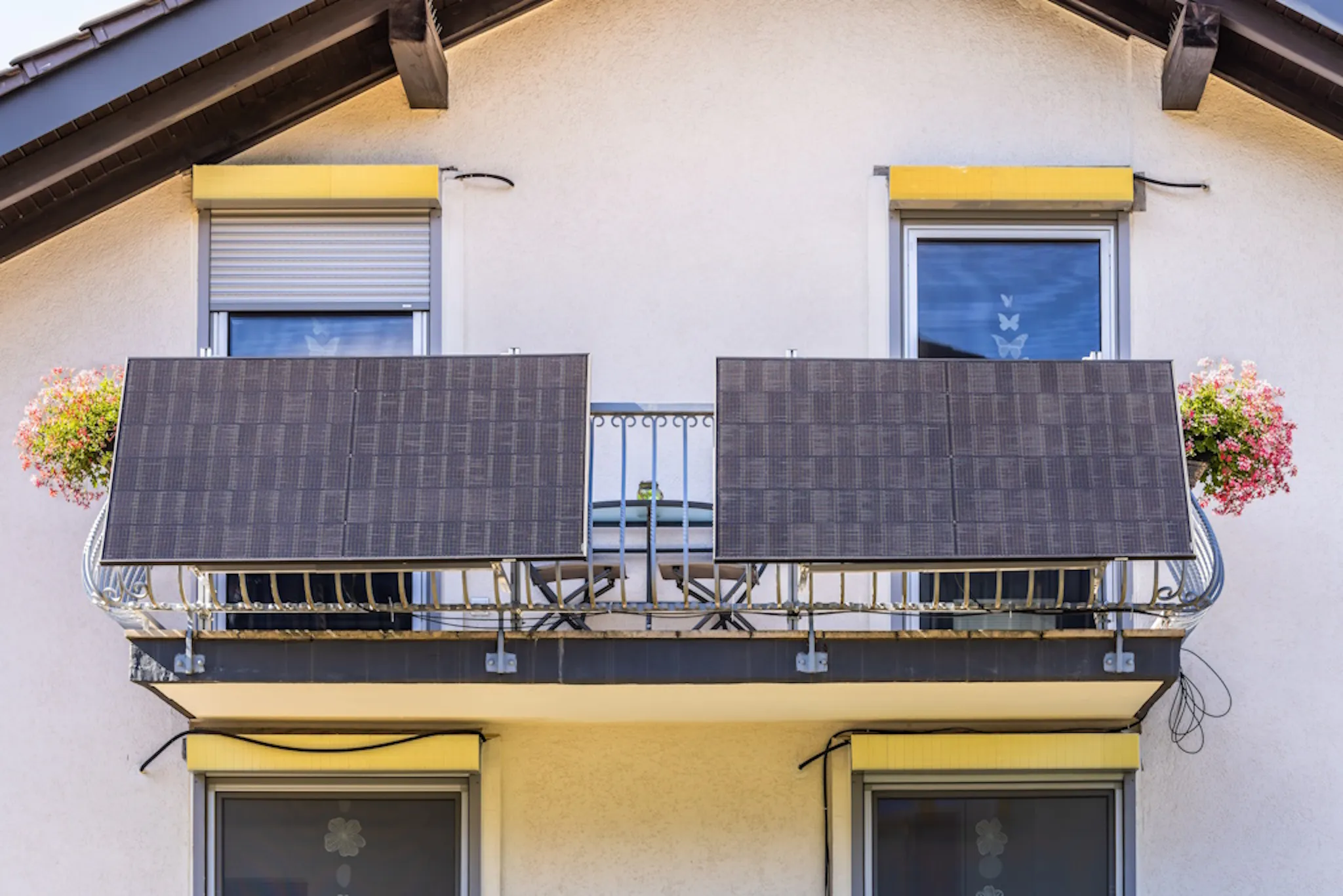 black plug-in solar panels attached to a balcony
