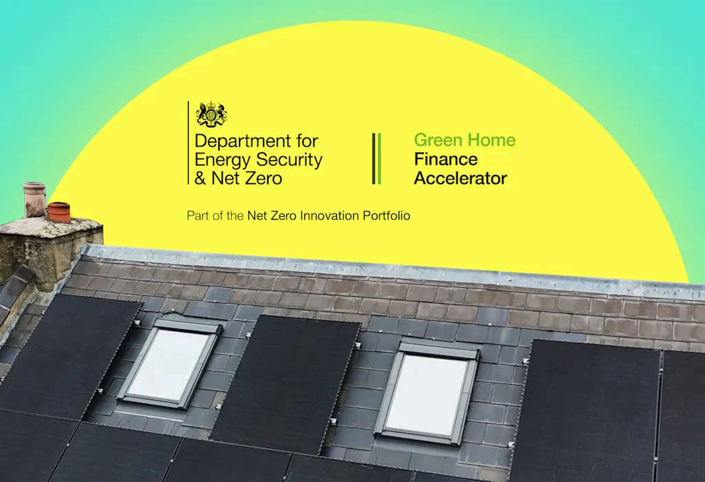 a grey roof with black solar panels, under a yellow semi-circle representing the sun, behind the logos of the Department for Energy Security and Net Zero and Green Home Finance Accelerator, all against an aquamarine background