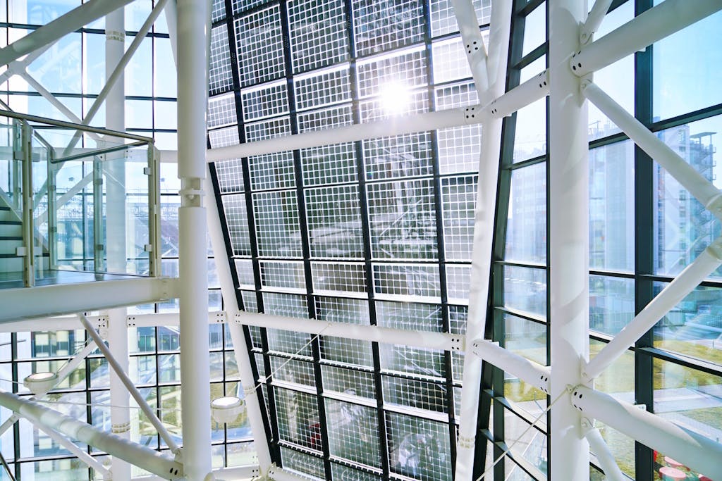 Transparent solar panels on a building, with the sky and other buildings in the background