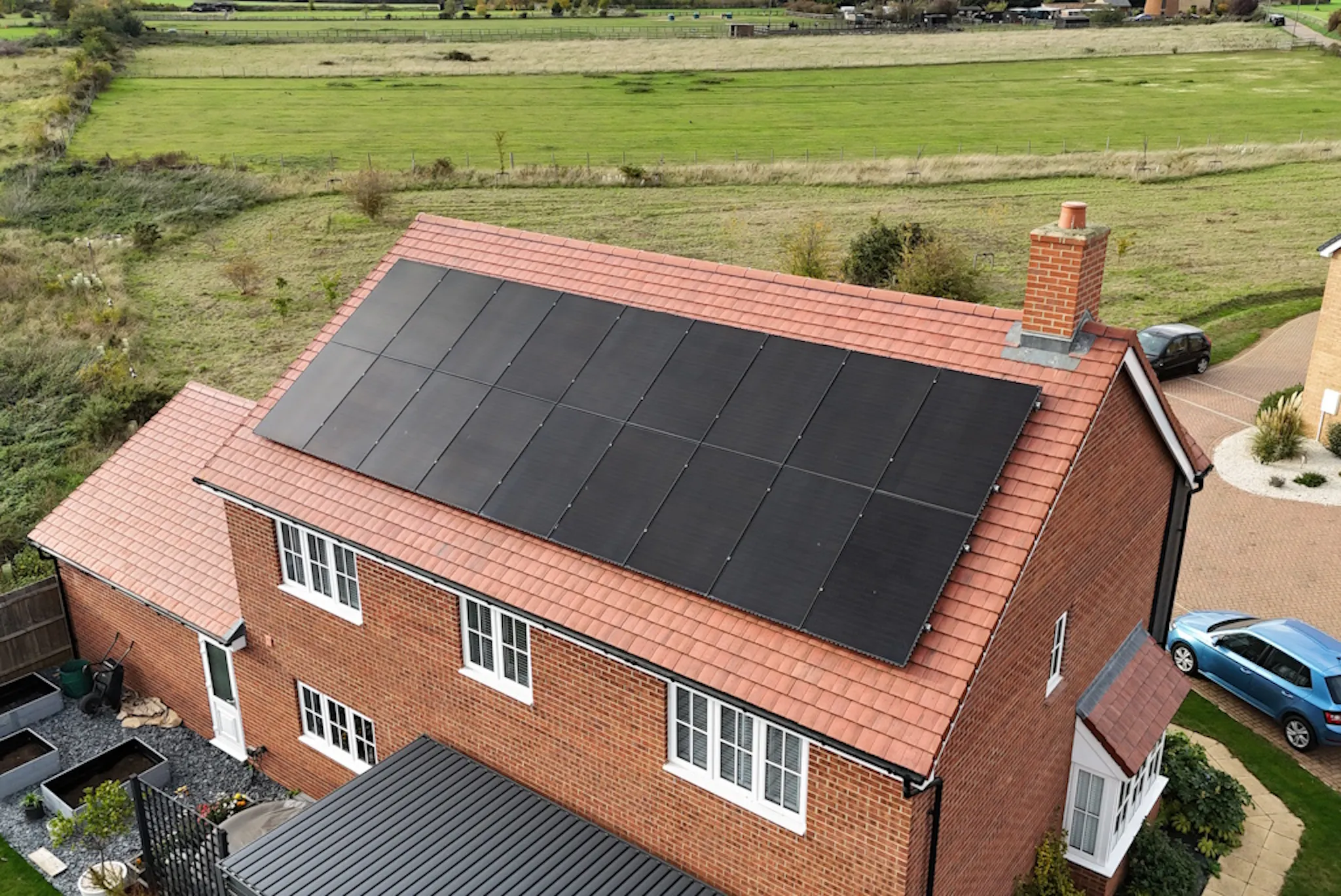 A brick house with black solar panels on the roof