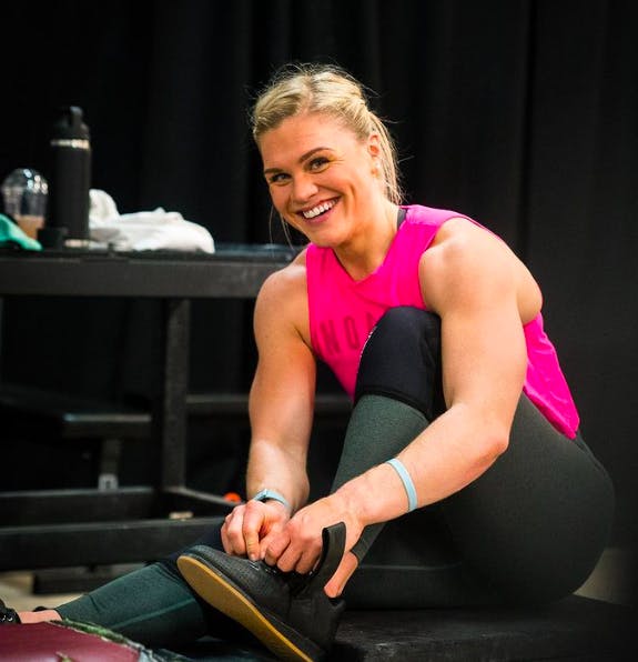 Katrin at the gym, putting on her shoes for a workout session.