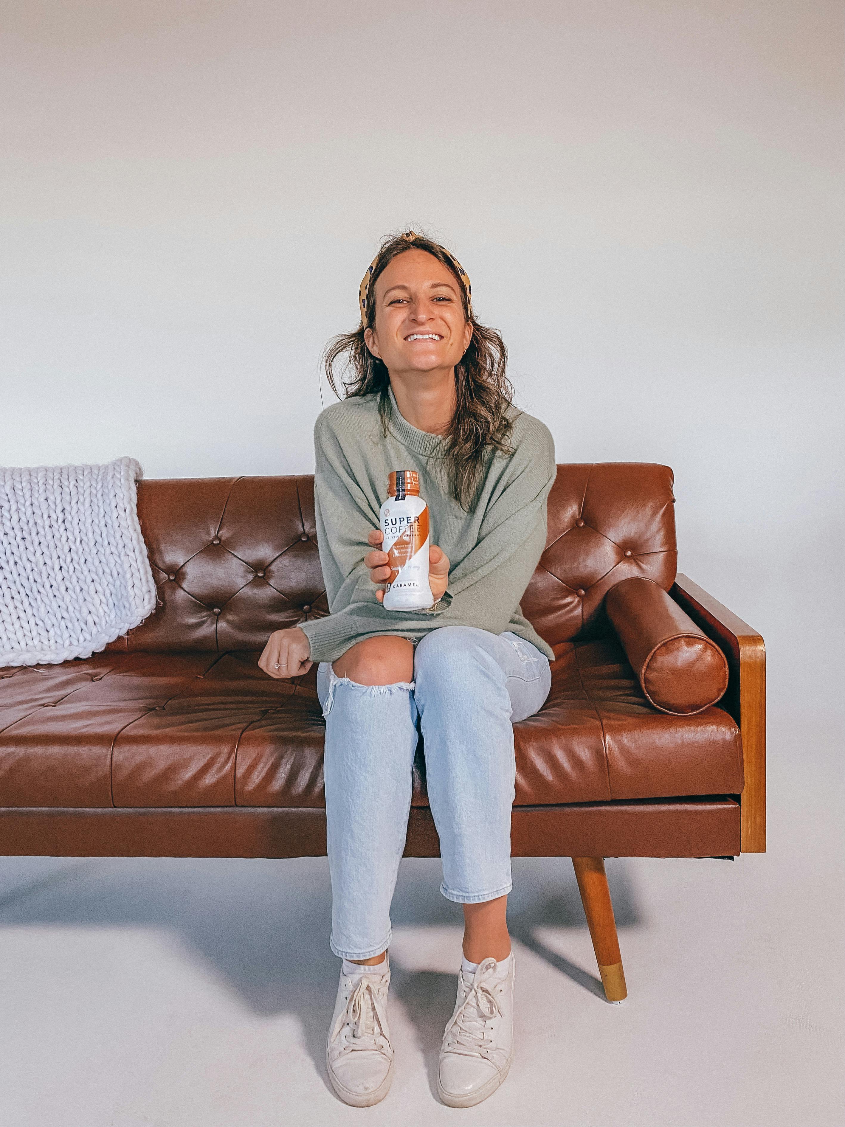 Lauren sitting on a couch with Super Coffee