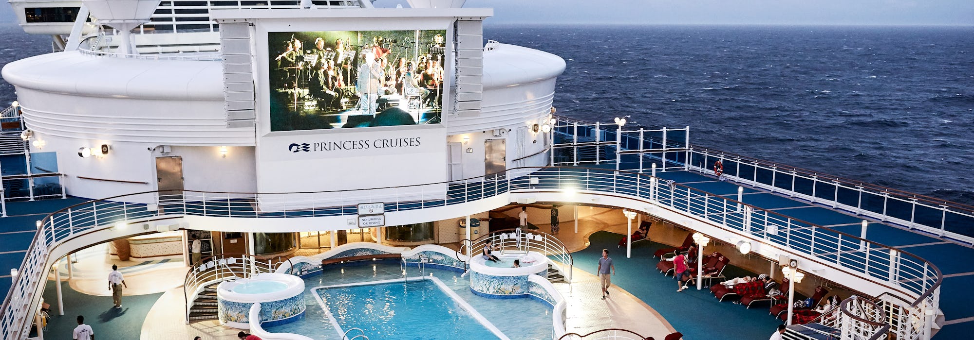 Bild uppifrån på fartyget Diamond Princess poolområde, i överkant syns också fartygets stora bio-skärm.
