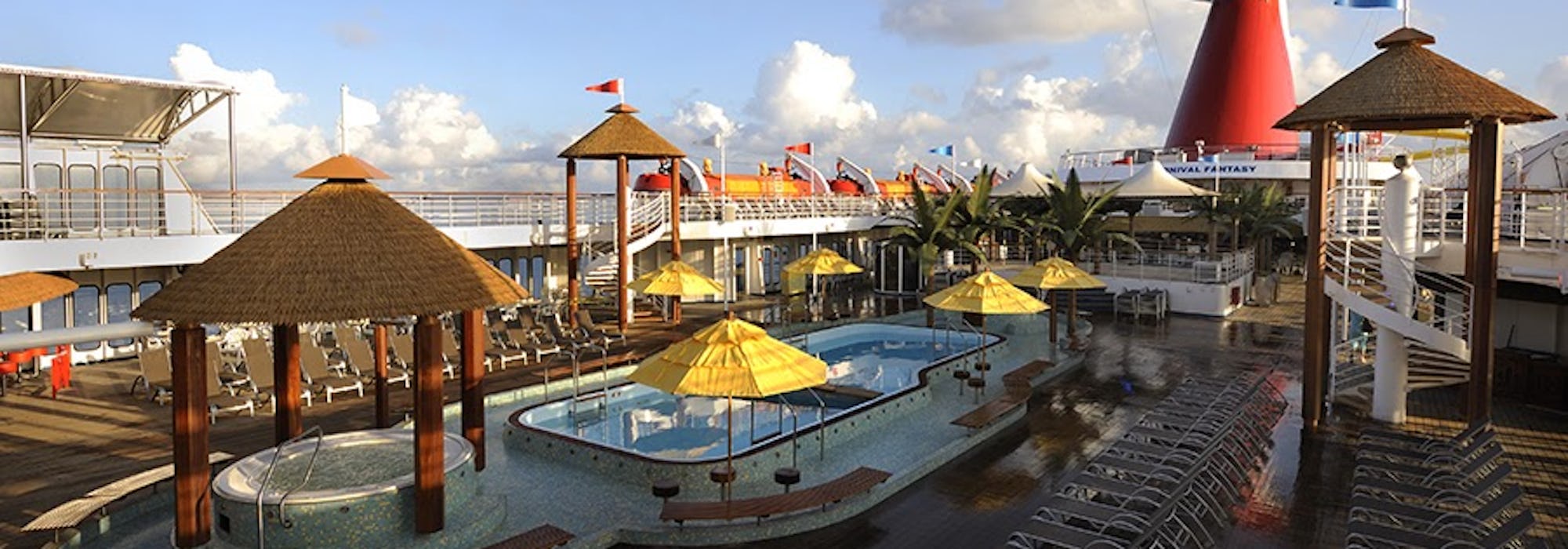 Bild på Carnival Fantasy's sol- och pooldäck med flera solsängar, jacuzzi och en pool.