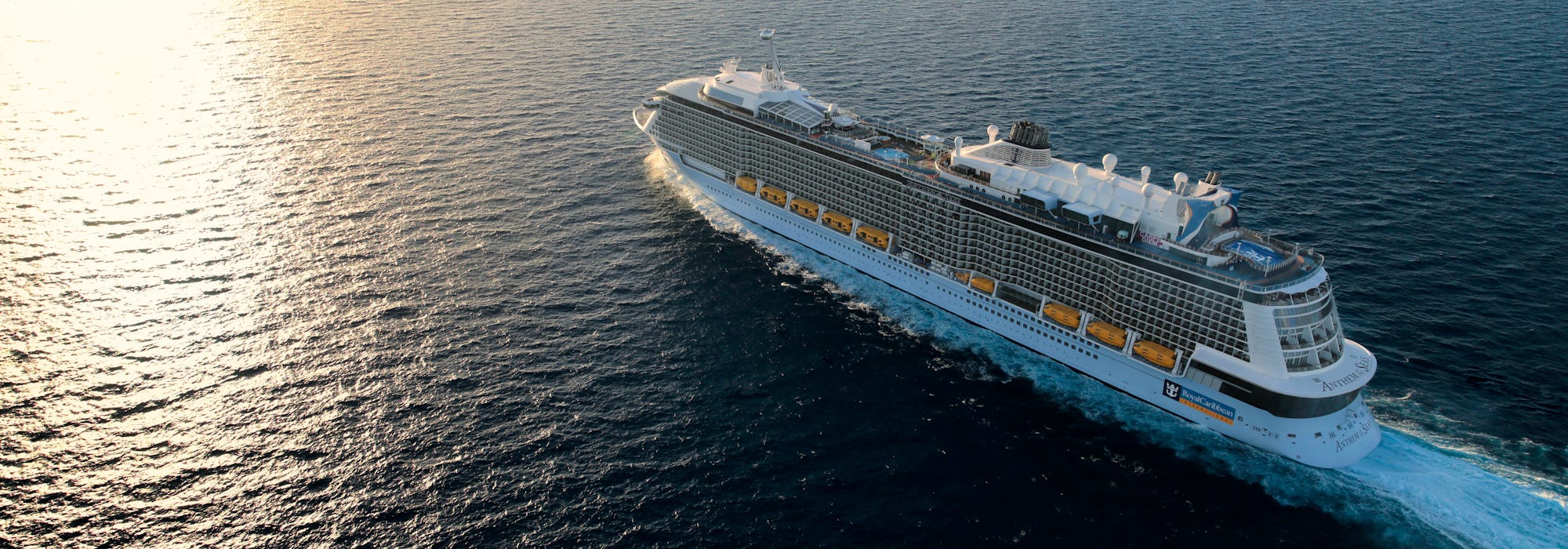 Bild tagen från ovan när fartyget Anthem of the Seas kryssar fram i det mörka vattnet i soluppgången.