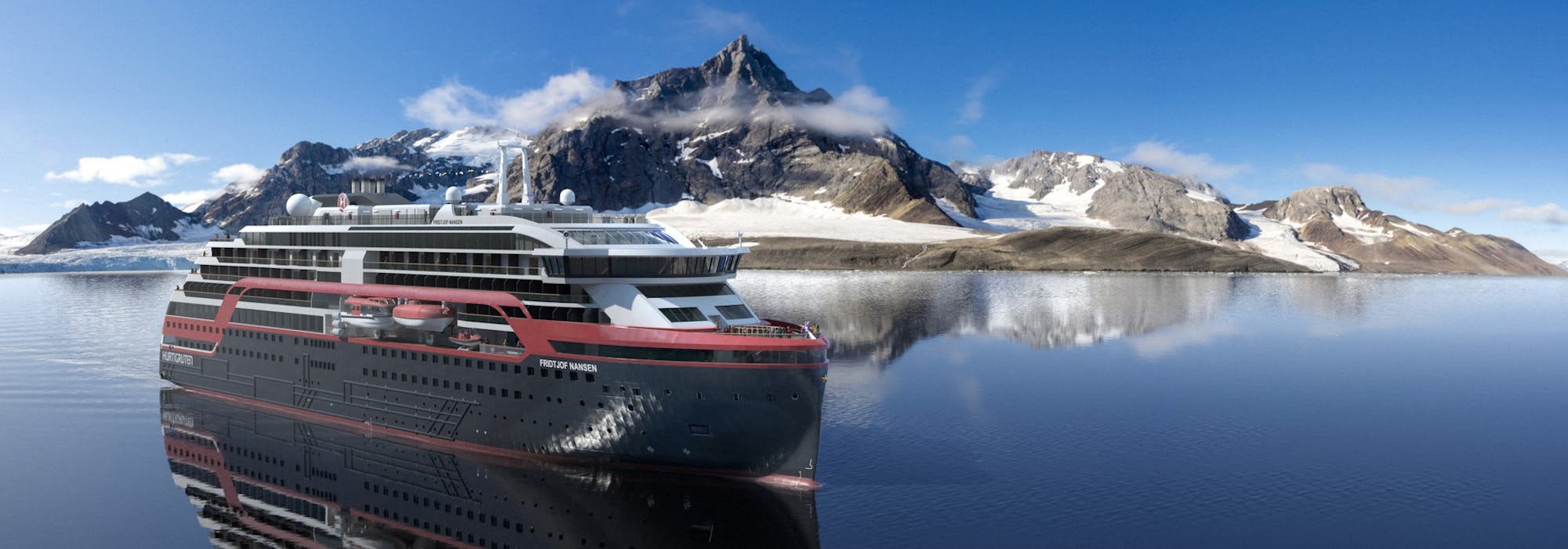 Hurtigrutens fartyg MS Fridtjof Nansen glider fram i vattnet vid Svalbard och dess vackra berg i bakgrunden.