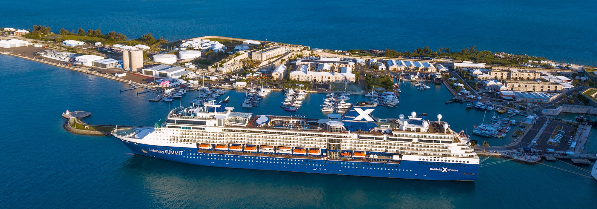 Bild från sidan på Celebrity Summit som passerar en liten ö och marina.