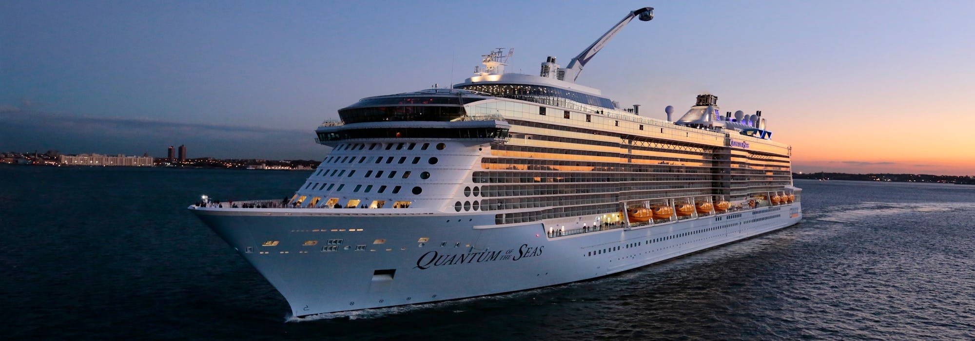 Bild på Quantum of the Seas tagen snett framifrån i solnedgången.