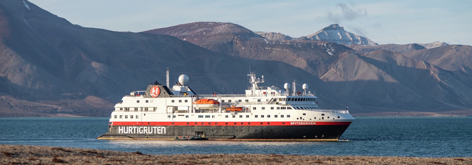 Bild från Svalbard på Hurtigrutens fartyg som kryssar fram mellan bergen.