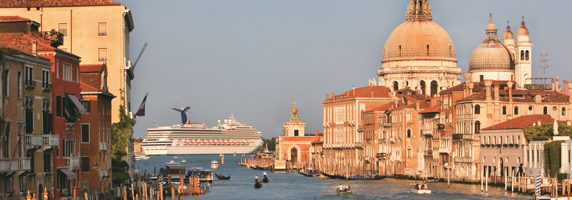 Fartyget Carnival Liberty kryssar fram utanför Venedig. På bilden syns vackra byggnader och gondoler.