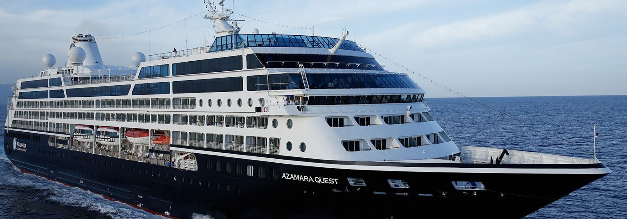Bild snett från sida på Azamara Quest som kryssar fram i det mörkblå havet.