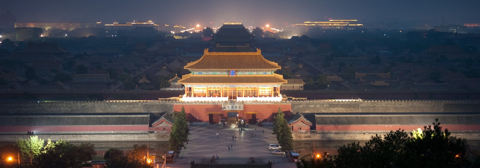 Bild på den förbjudna staden i Peking tagen uppifrån med det ståtliga palatset upplyst i kvällsljuset.