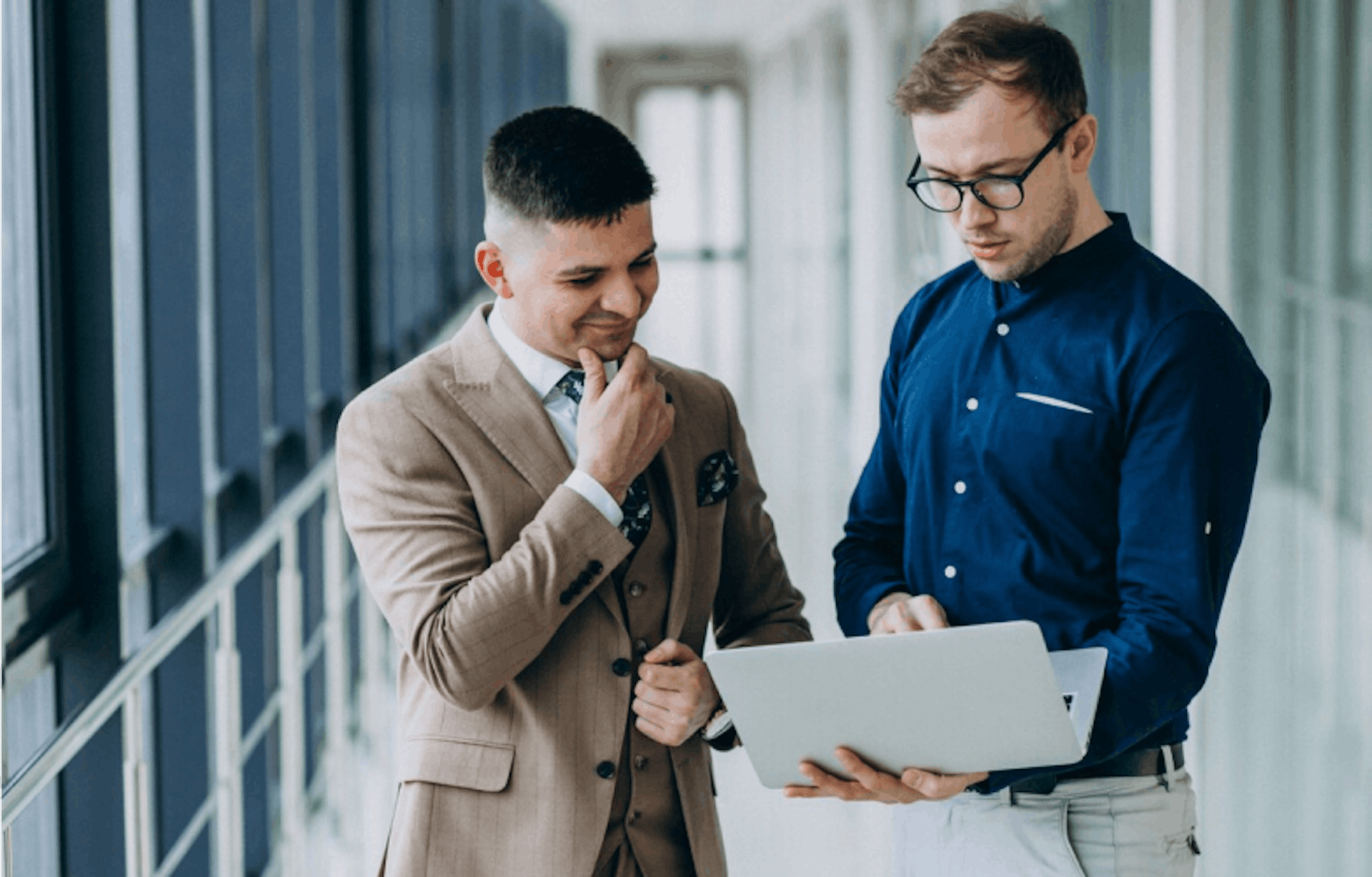 two people looking at a laptop