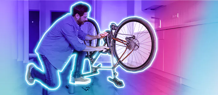 Hombre arreglando una bicicleta en casa