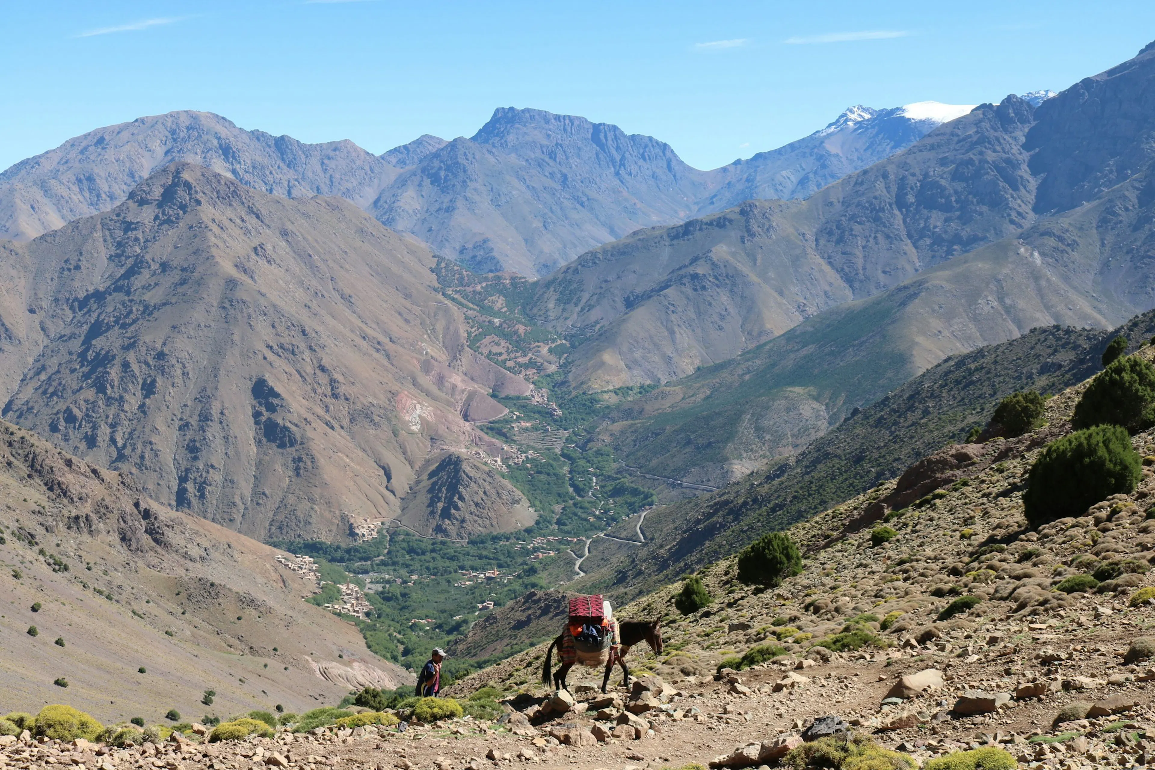 Paisaje del Alto Atlas marroquí con un viajero y montañas al fondo