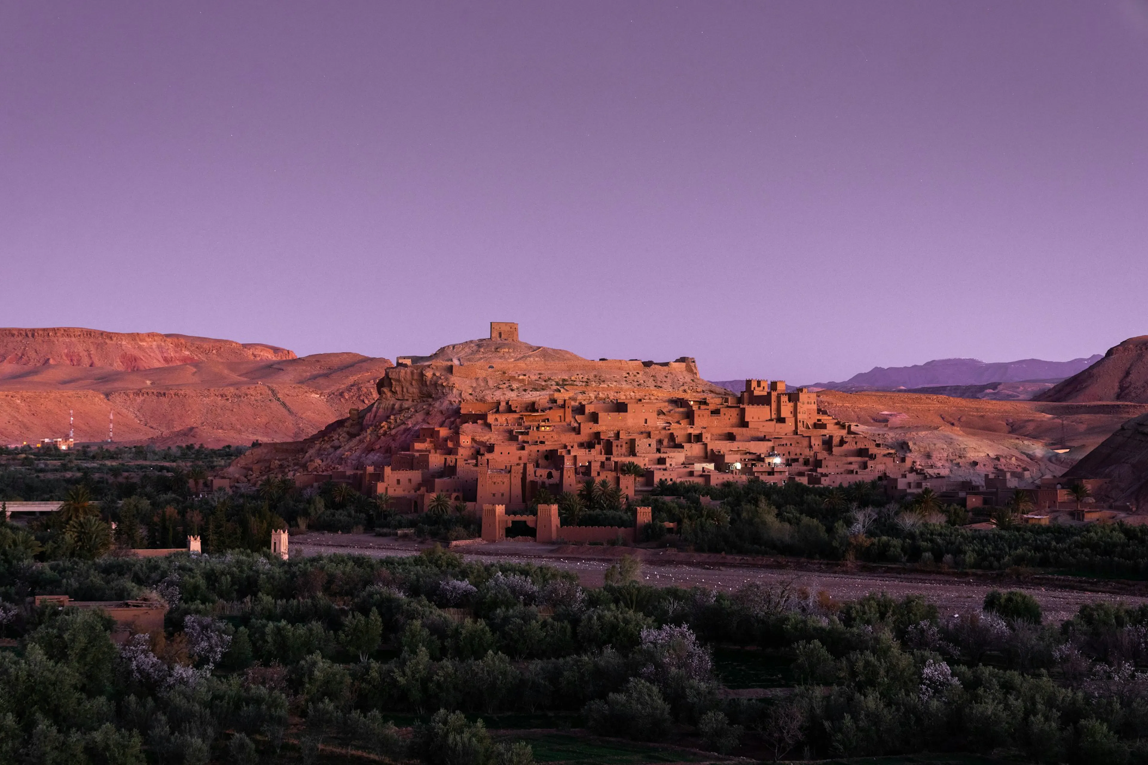 Kasbah marroquí rodeada de palmeras y montañas