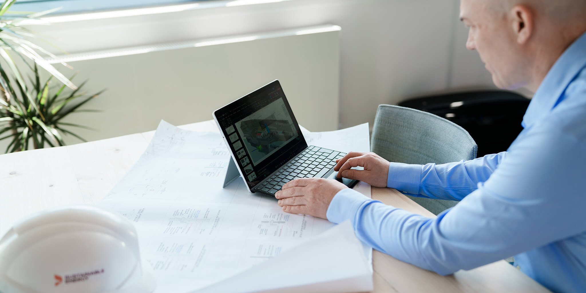 Man at desk in office with laptop