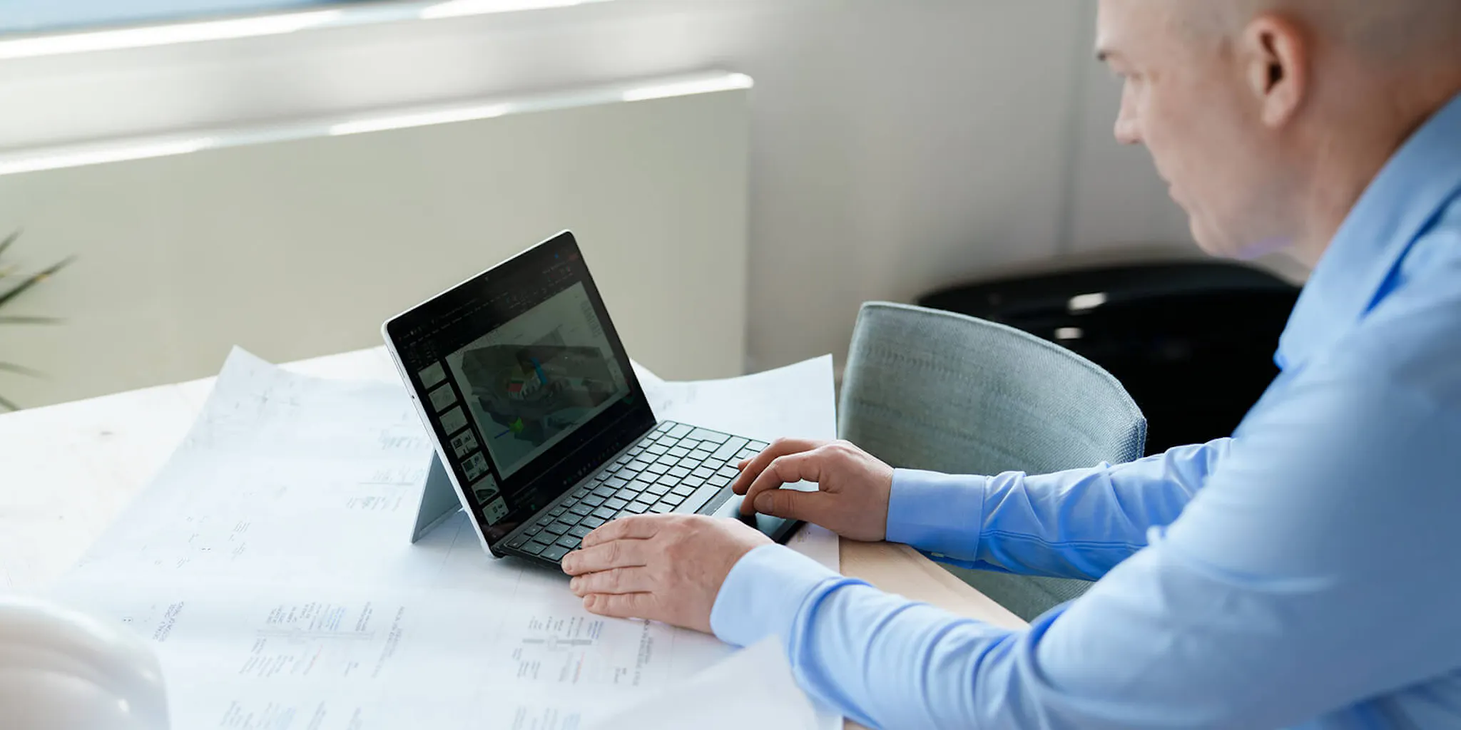 Man at desk in office with laptop
