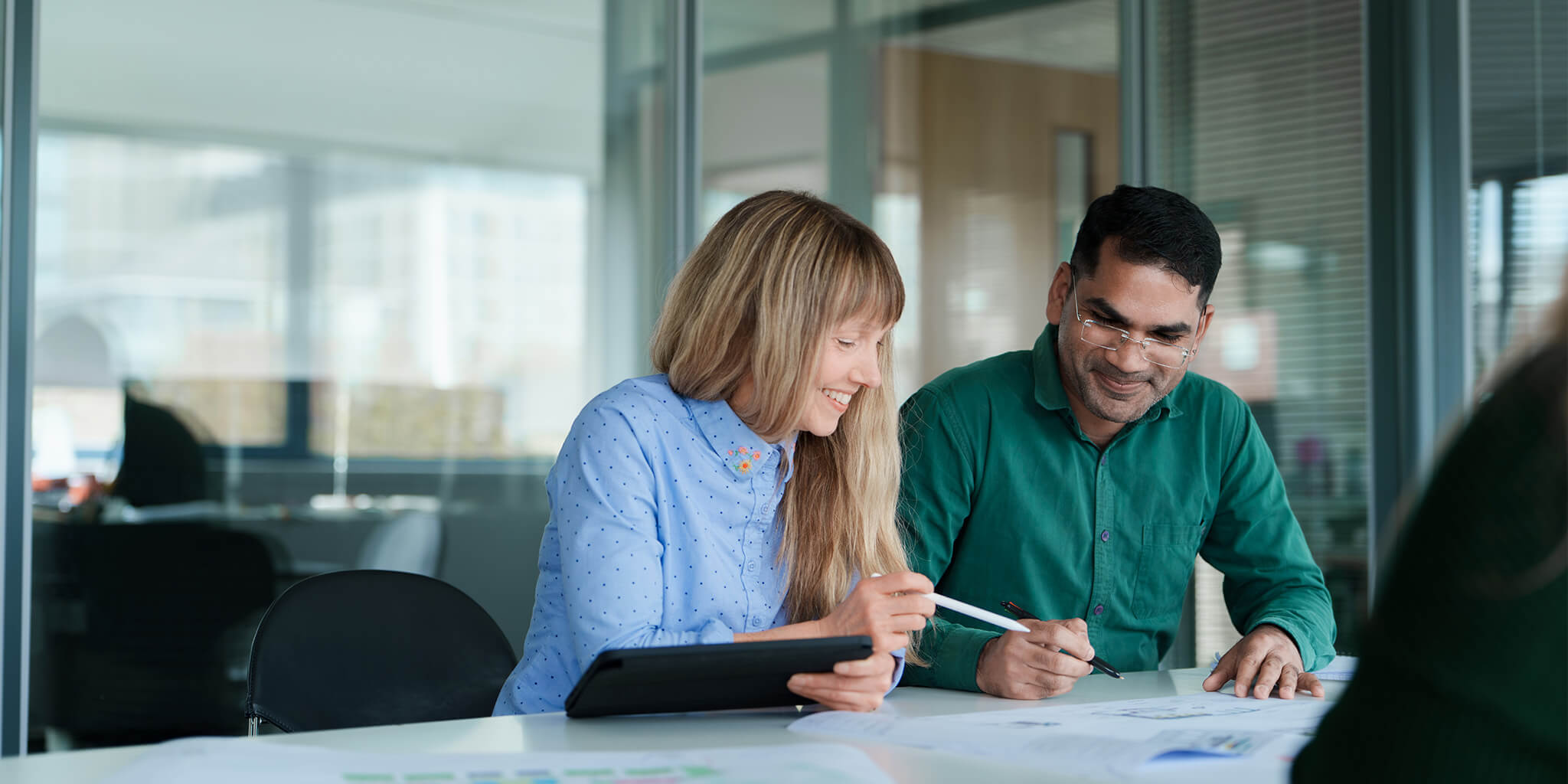Two people at a desk looking at a report