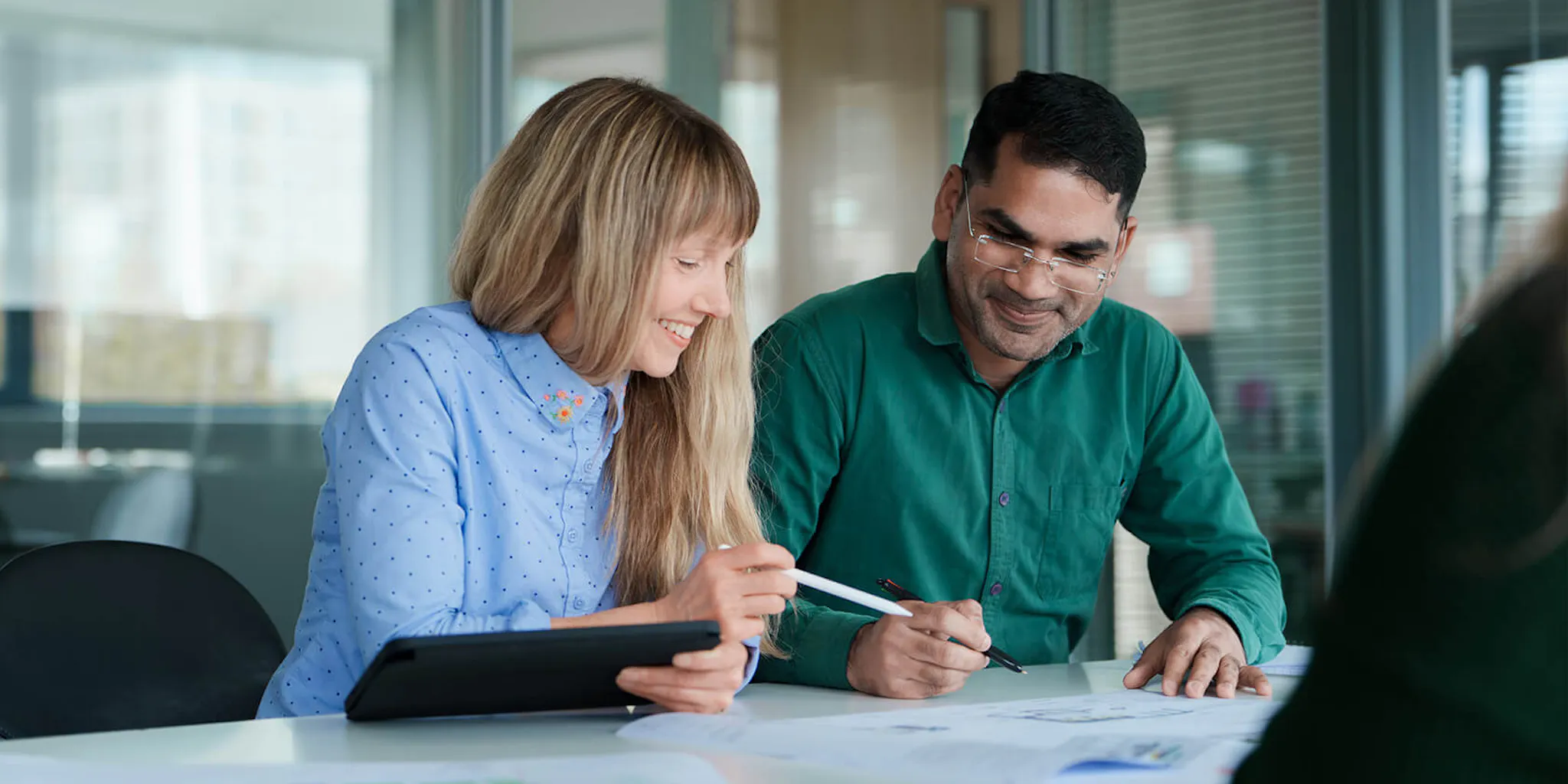 Two people at a desk looking at a report