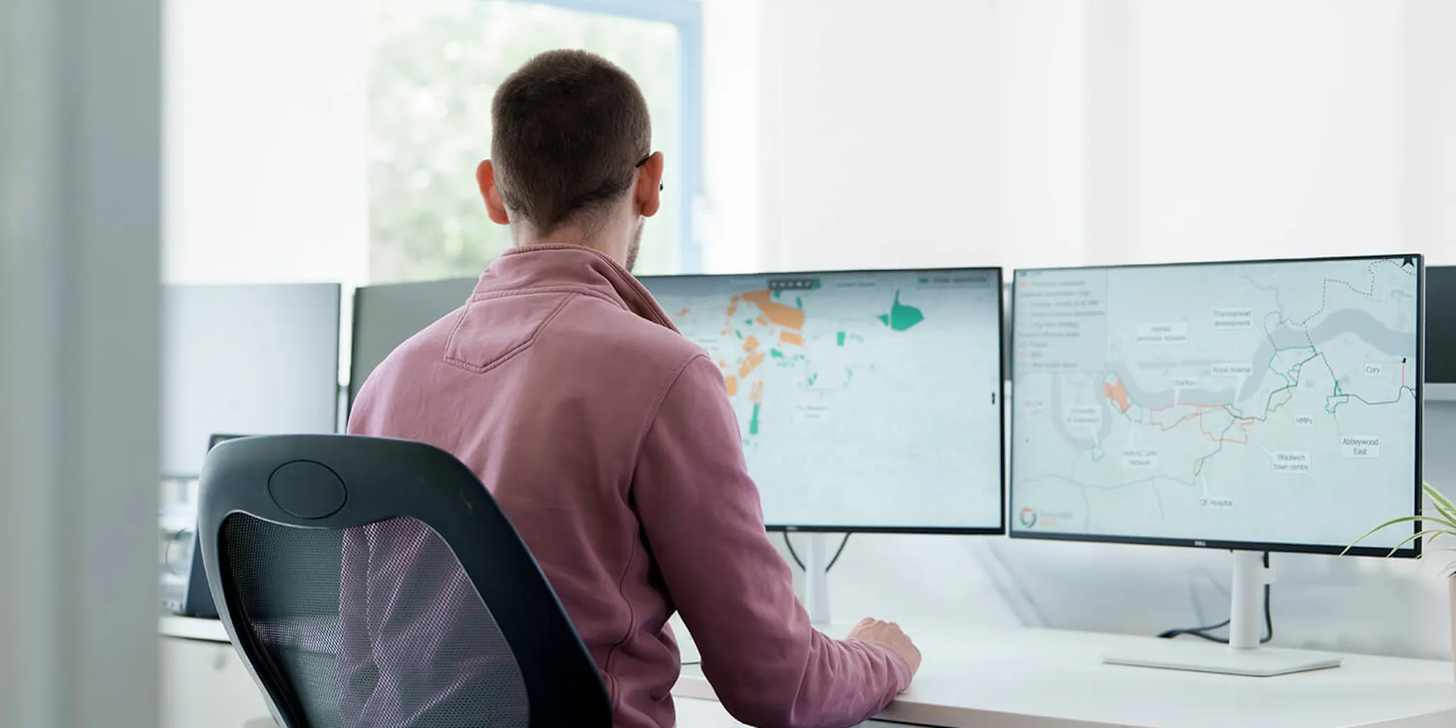 Man sat at desk looking at plans on monitors