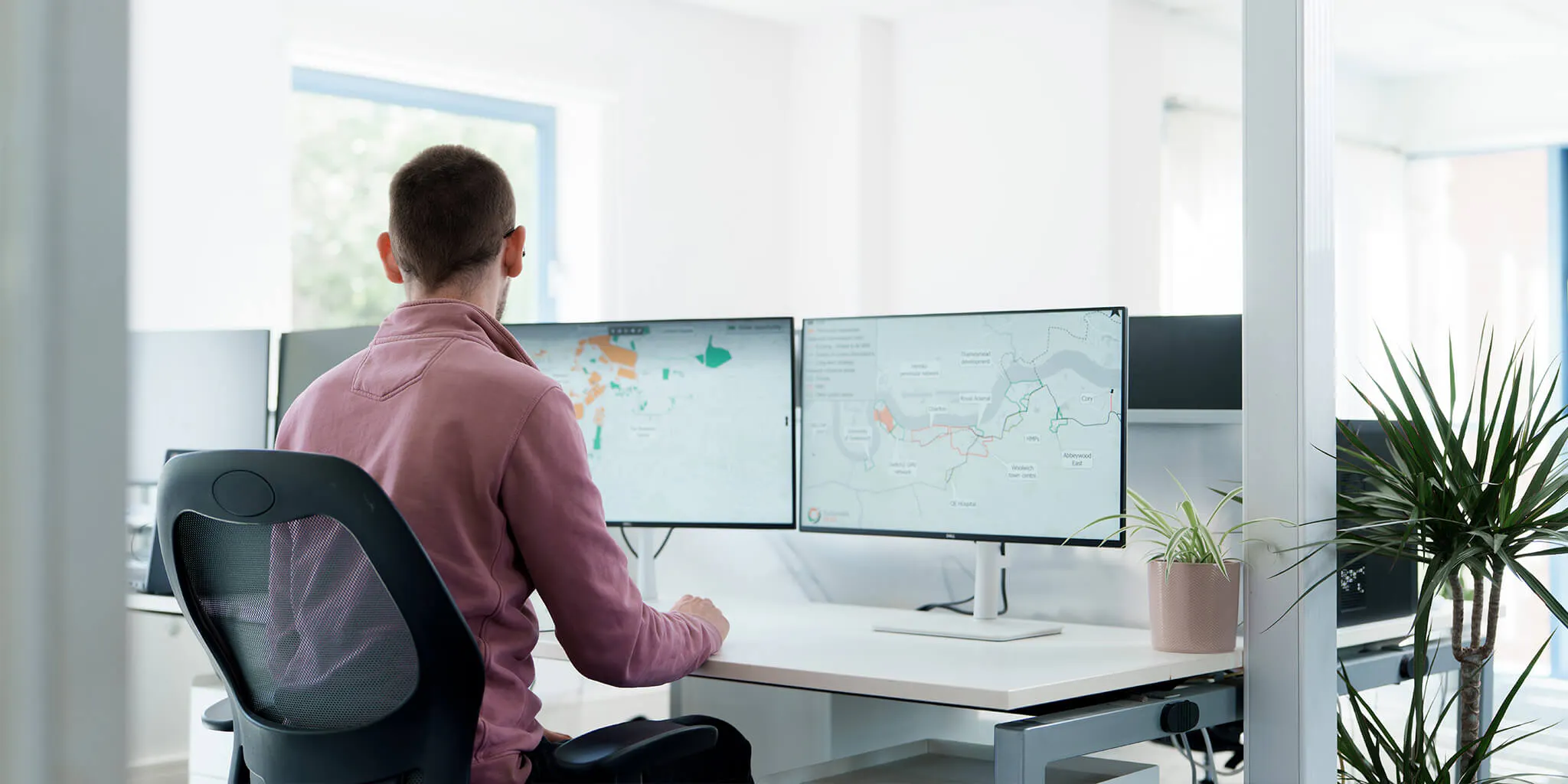 Man sat at desk looking at plans on monitors