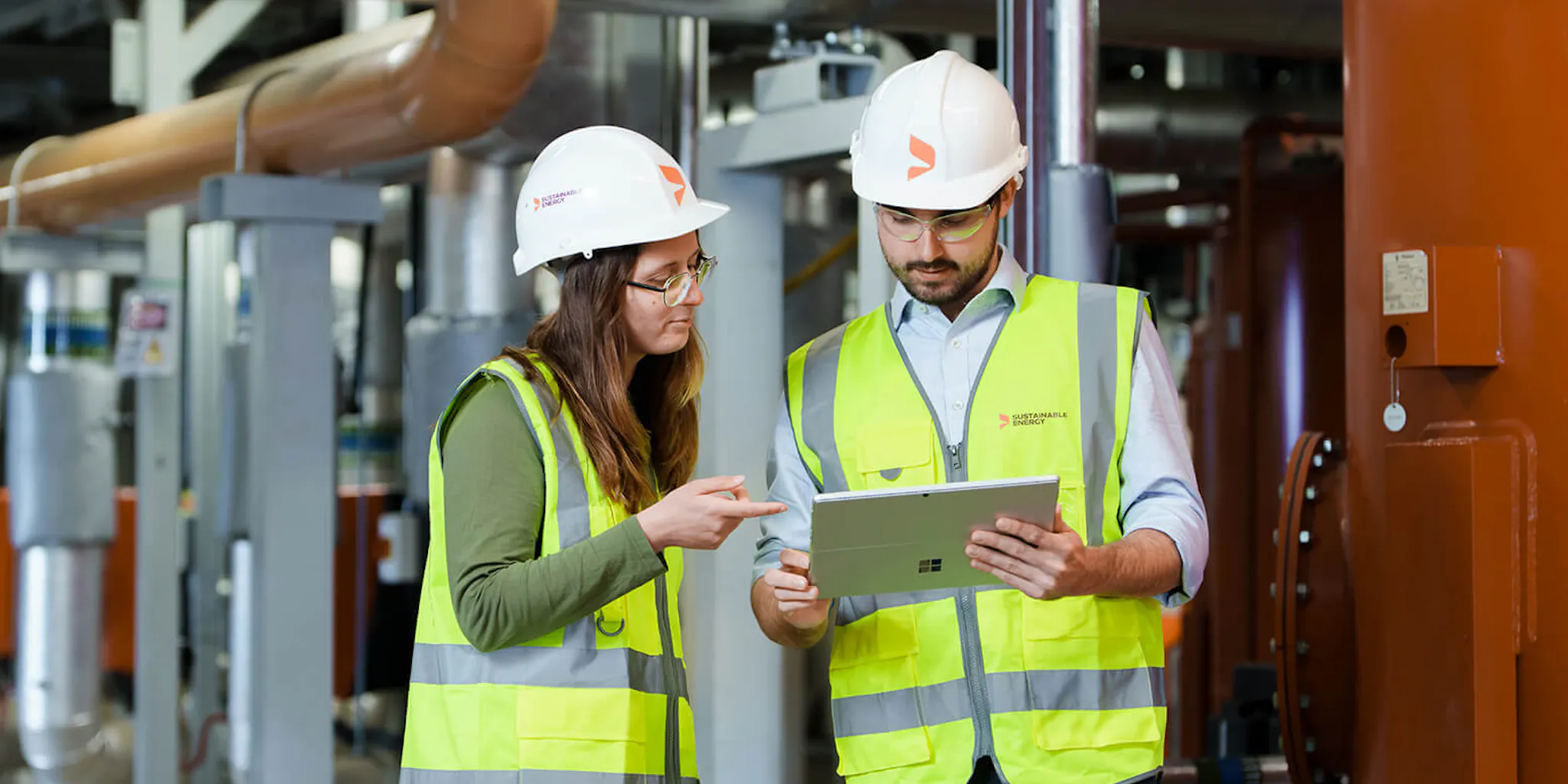 Two engineers on-site reading an energy report
