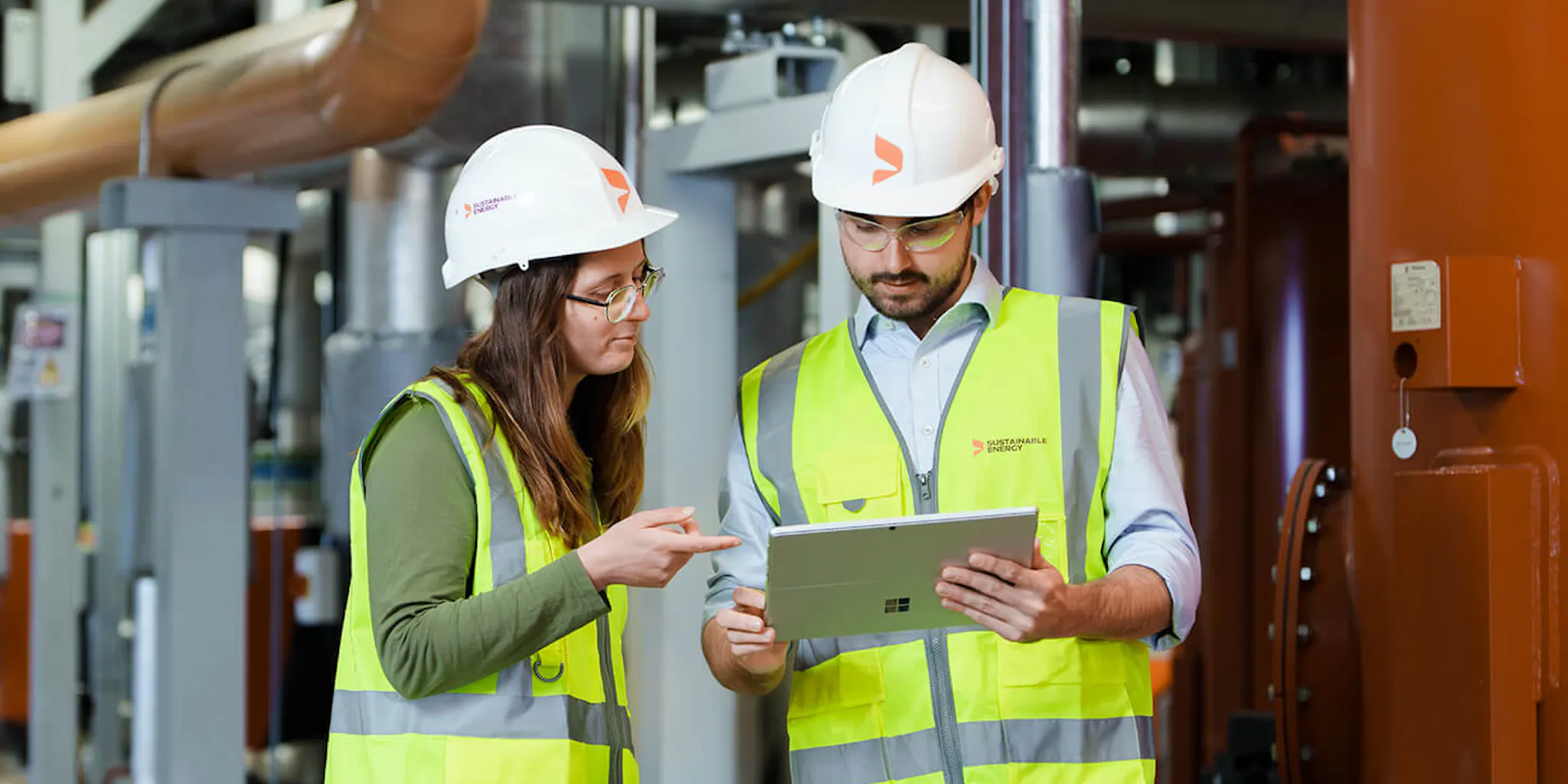 Two engineers on-site reading an energy report