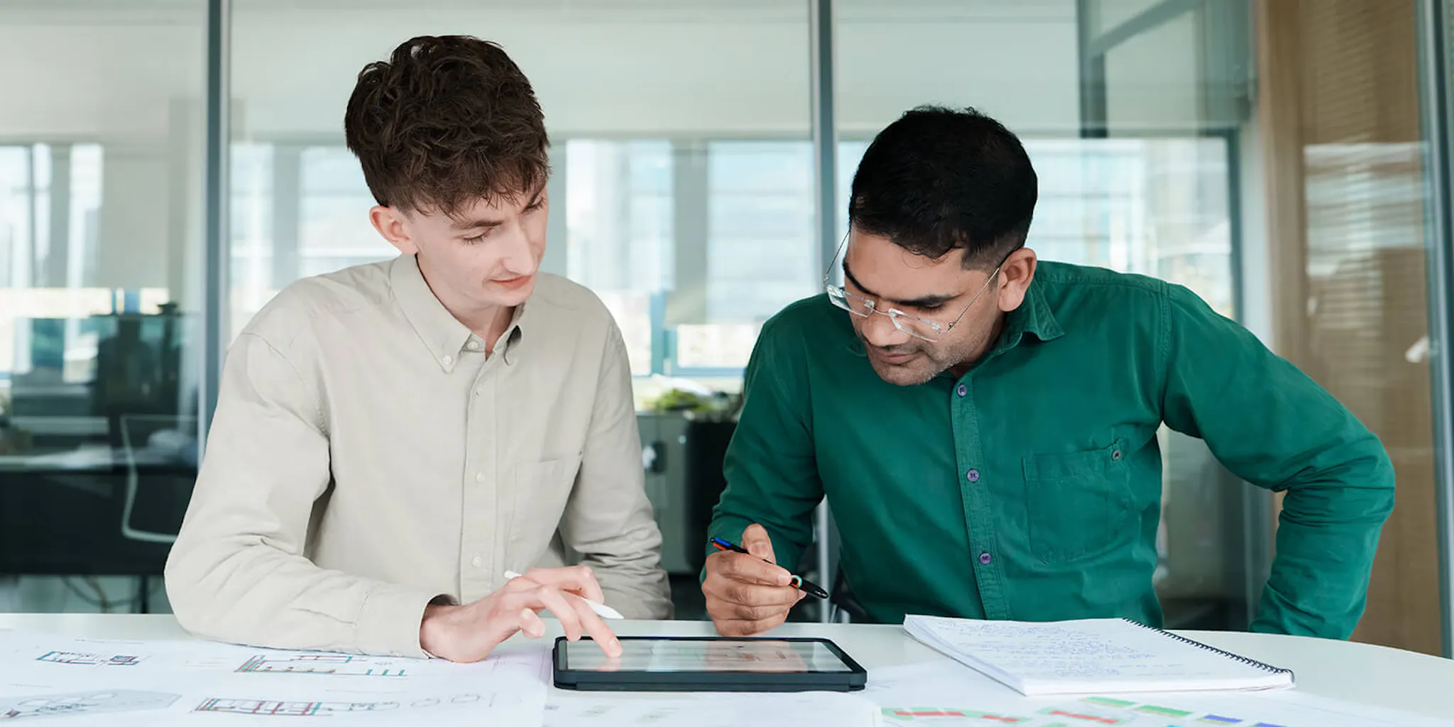 Two colleagues in an office looking at plans