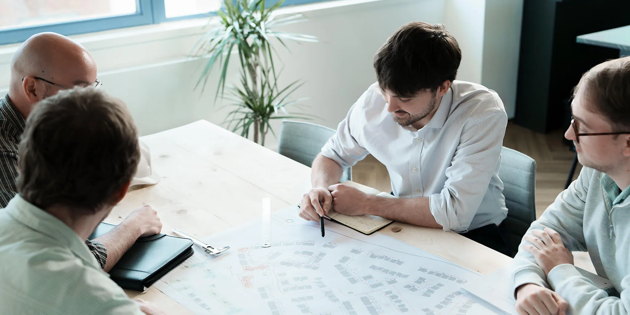 Employees sat around a desk discussing plans
