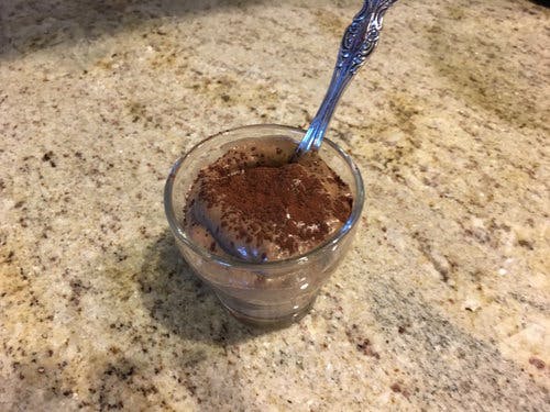Cup of chocolate mousse with a sprinkle of chocolate powder