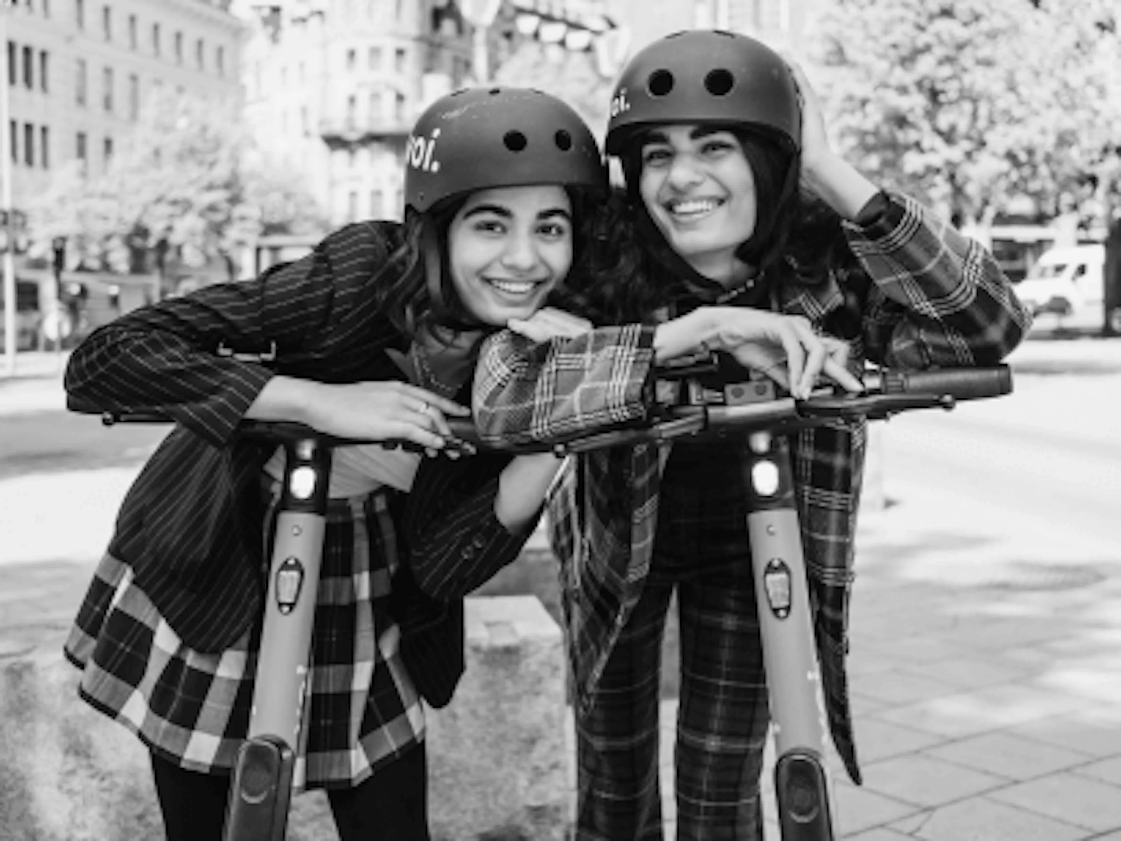 Zwei Frauen mit Helmen auf E-Scootern