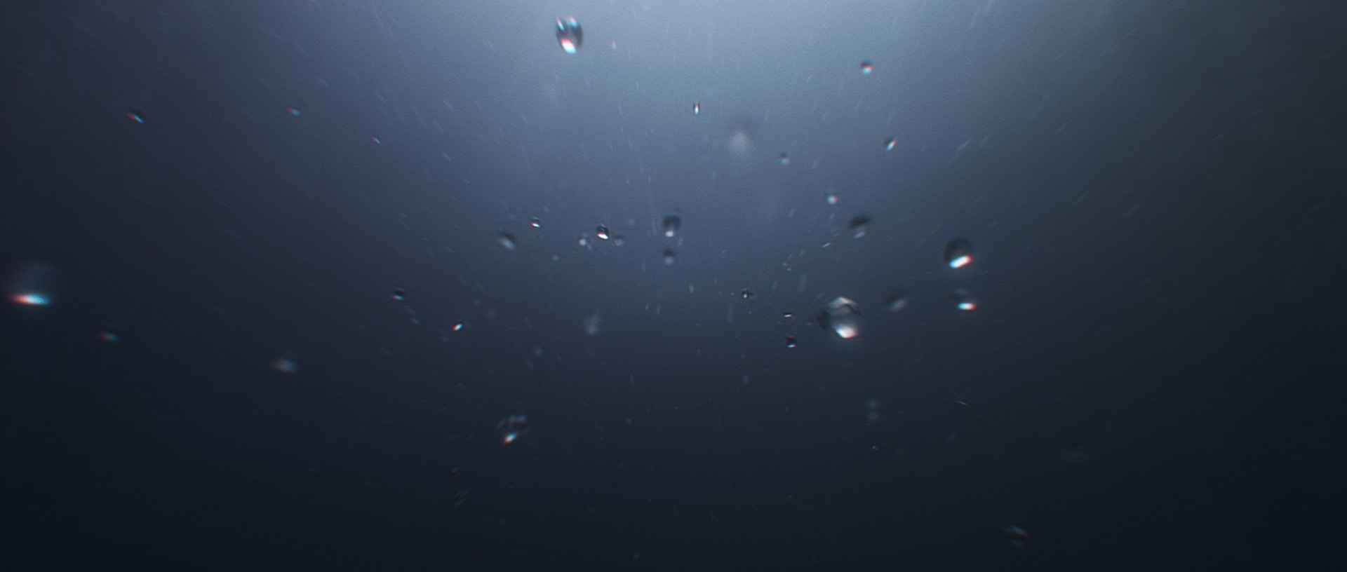 Bubbles underwater in a dark ocean.