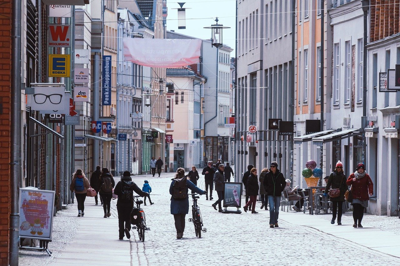 People walking and cycling along a busy pedestrian street in a Nordic town