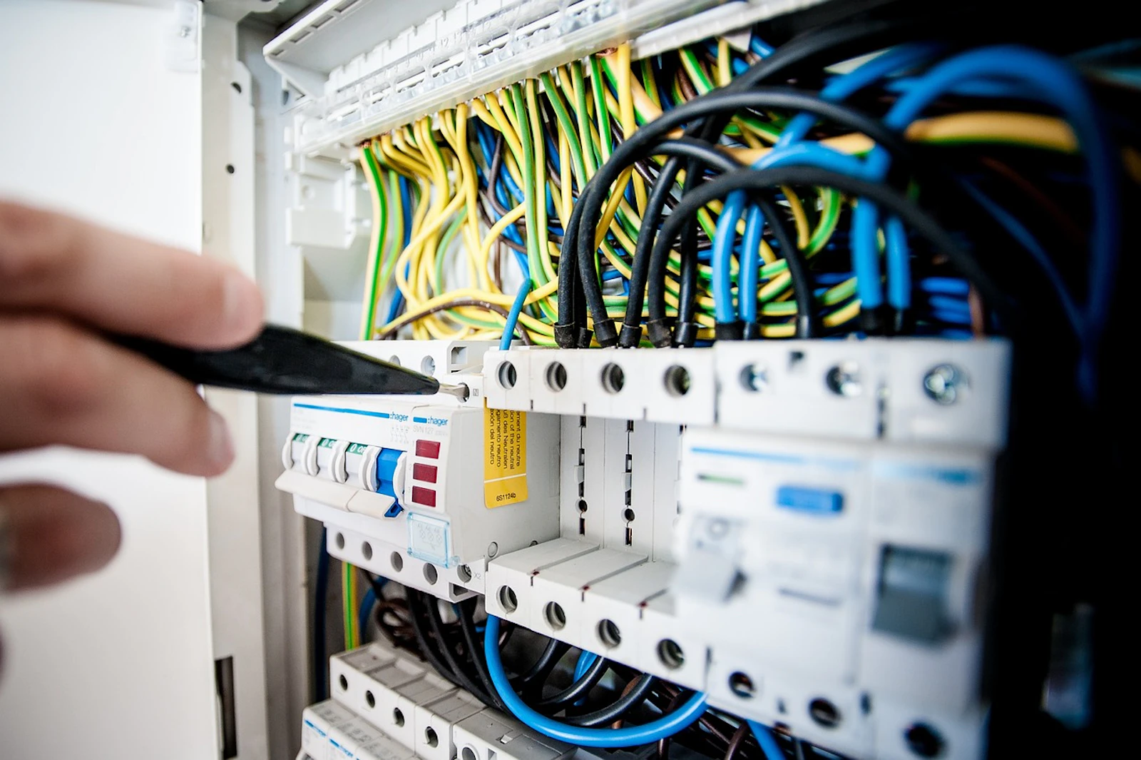 Close-up of an electrical control panel with circuit breakers and coloured wiring
