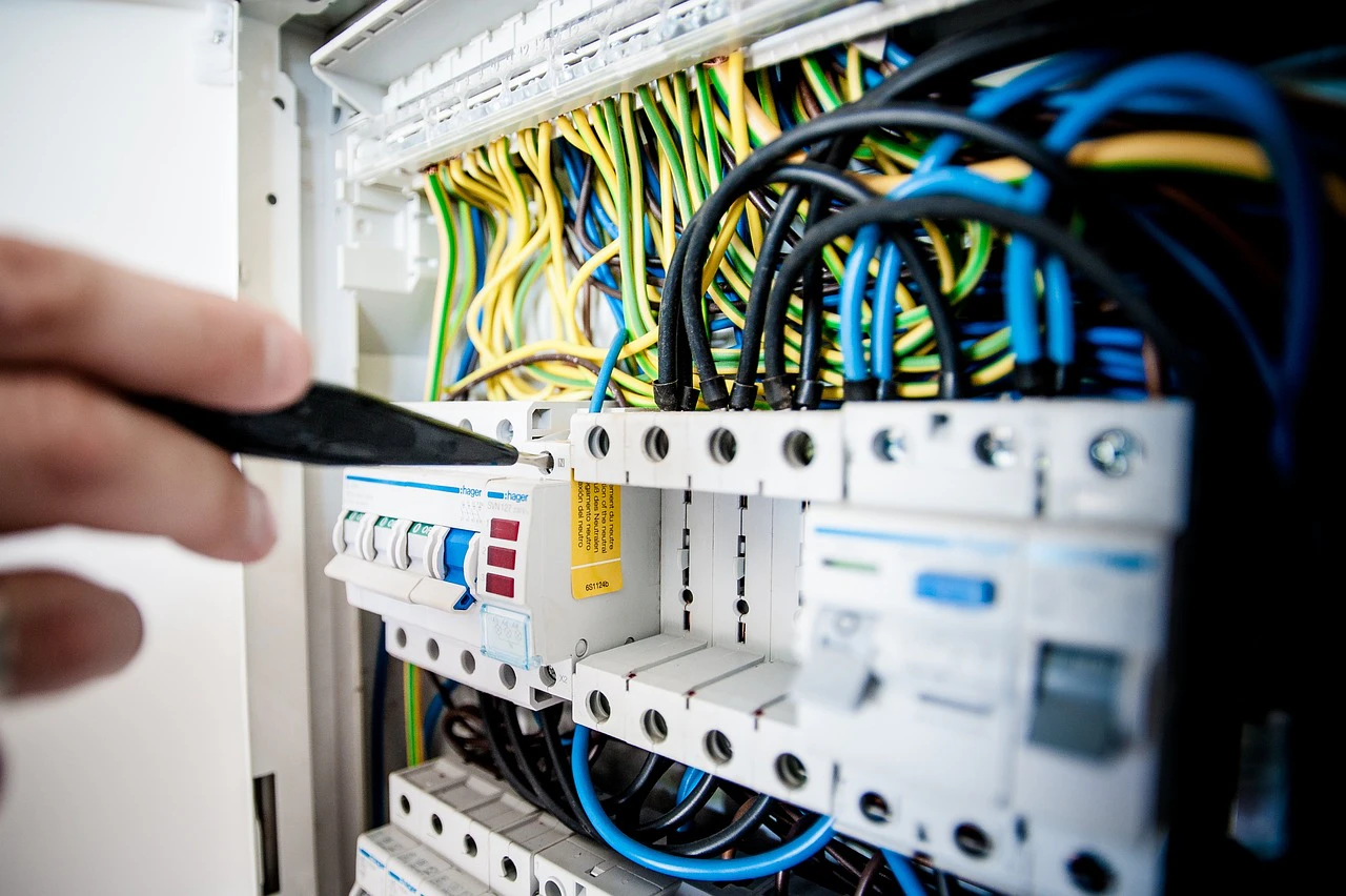 Close-up of an electrical control panel with circuit breakers and coloured wiring